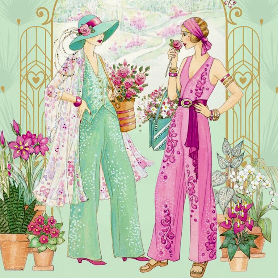 Two women wearing decorated pastel pant suits with floral designs in an elegant garden with flowering plants
