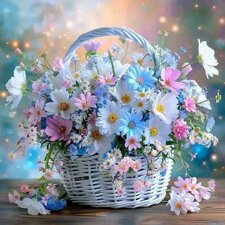 White wicker basket filled with colorful pastel flowers including daisies and cosmos with bokeh background