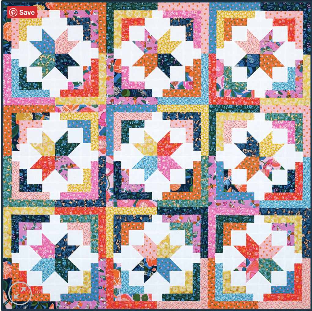 Colorful patchwork quilt with nine star-pattern blocks in bright floral fabrics on white background