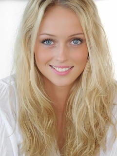 Portrait of smiling blonde woman with blue eyes and long wavy hair