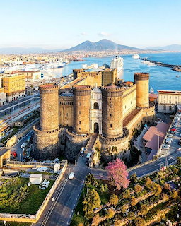 Aerial view of Castel Nuovo castle in Naples with Mount Vesuvius and harbor in the background