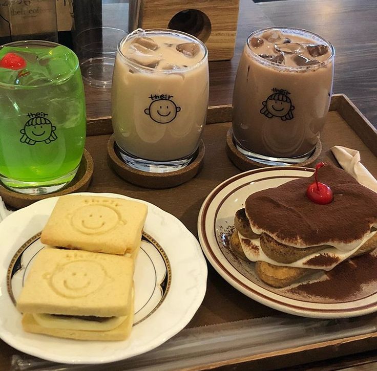 Tray with iced drinks, pancakes, and smiley toast on plates