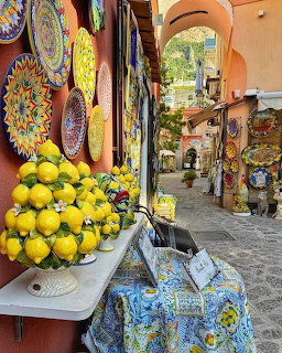Italian alley with colorful ceramic plates and baskets of lemons on display