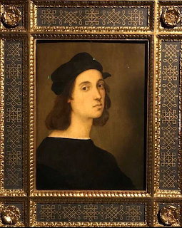 Renaissance painting of young man in dark beret and clothing in ornate gold frame