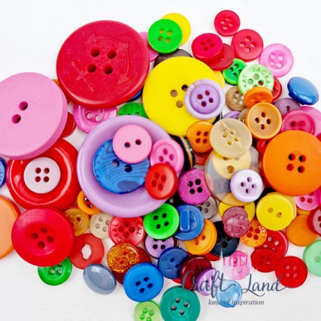 Assorted colorful sewing buttons of various sizes piled together on a white background