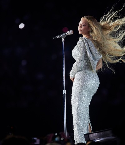 Beyoncé singing on stage in silver sequined dress with flowing hair