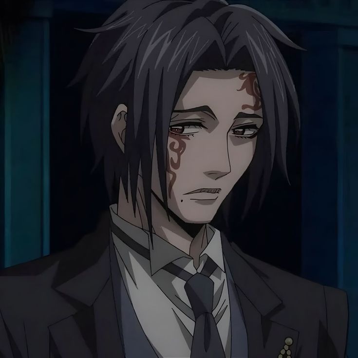 Anime man with long dark hair, suit and tie, and facial markings in a dim room