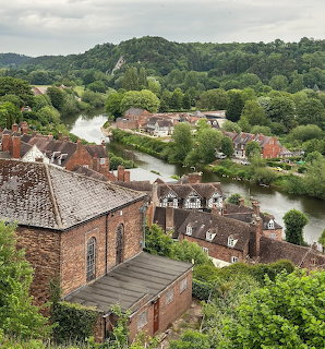 Elevated view of Bridgnorth town with brick buildings along a river surrounded by green hills