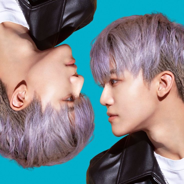 Mirrored portrait of person with purple-gray hair and black leather jacket on turquoise background