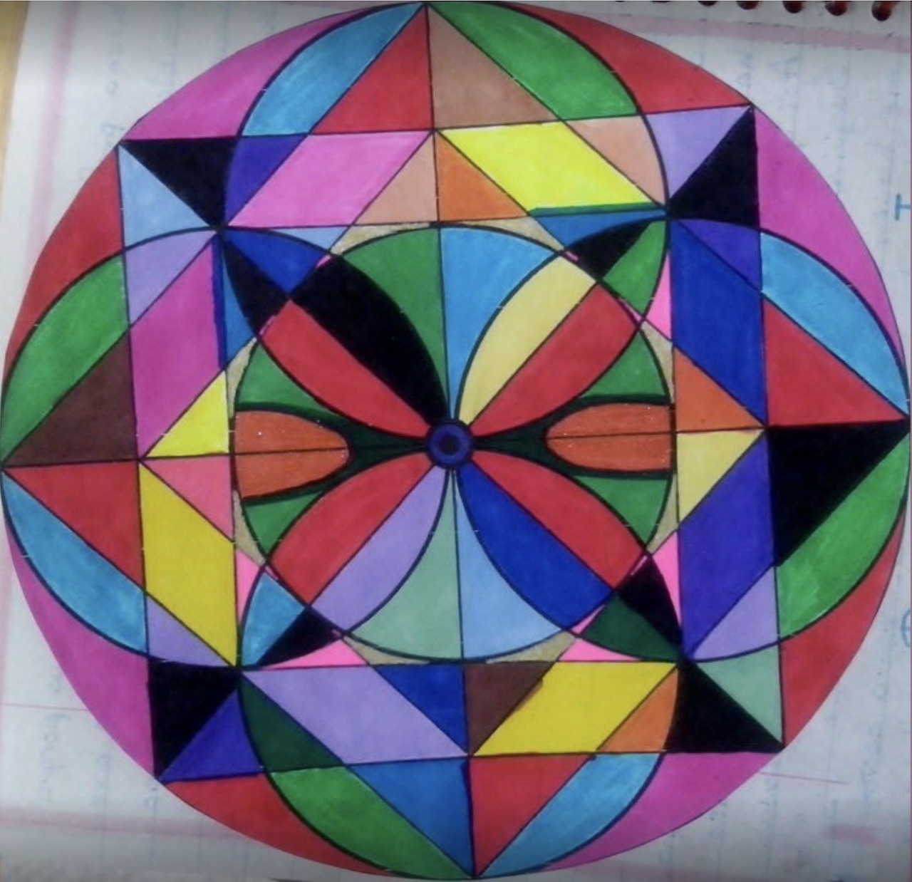 Colorful circular geometric mandala with triangular stained glass pattern on spiral notebook