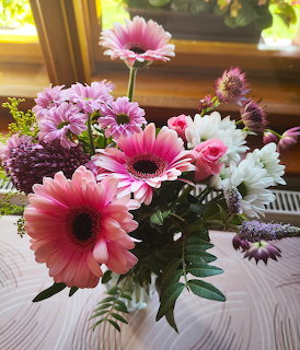 Vibrant flower bouquet with pink gerberas and mixed blooms in vase near window