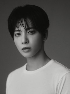 Black-and-white portrait of a young man with dark hair in a white shirt