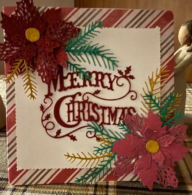 Handmade Merry Christmas card with poinsettias, pine branches, and candy cane striped border