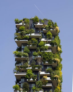 Tall building covered with lush green trees and plants on every balcony level