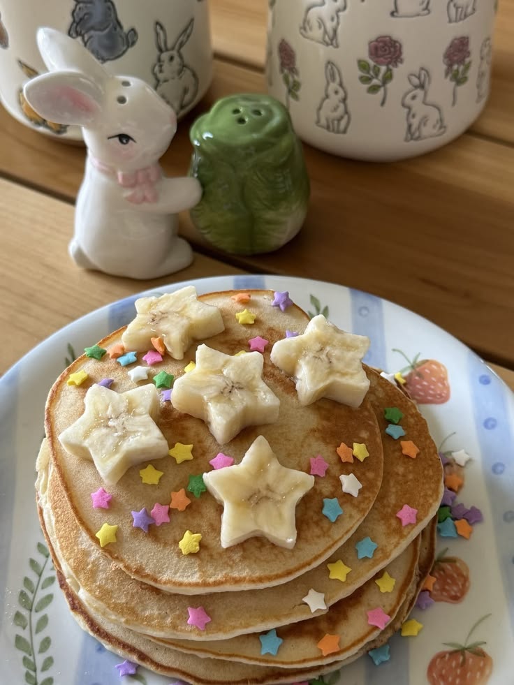 Stack of pancakes with banana star slices and colorful sprinkles on a plate