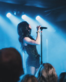 Chrissy Costanza, singer with long dark hair, posing for a portrait.