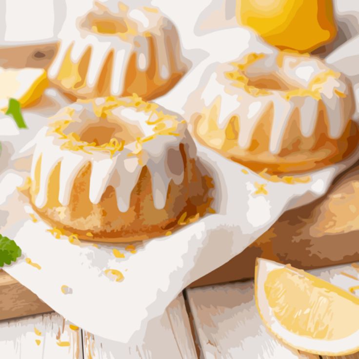 Three glazed mini lemon bundt cakes on a napkin with lemon slices