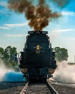 Vintage steam locomotive 953 on tracks with smoke
