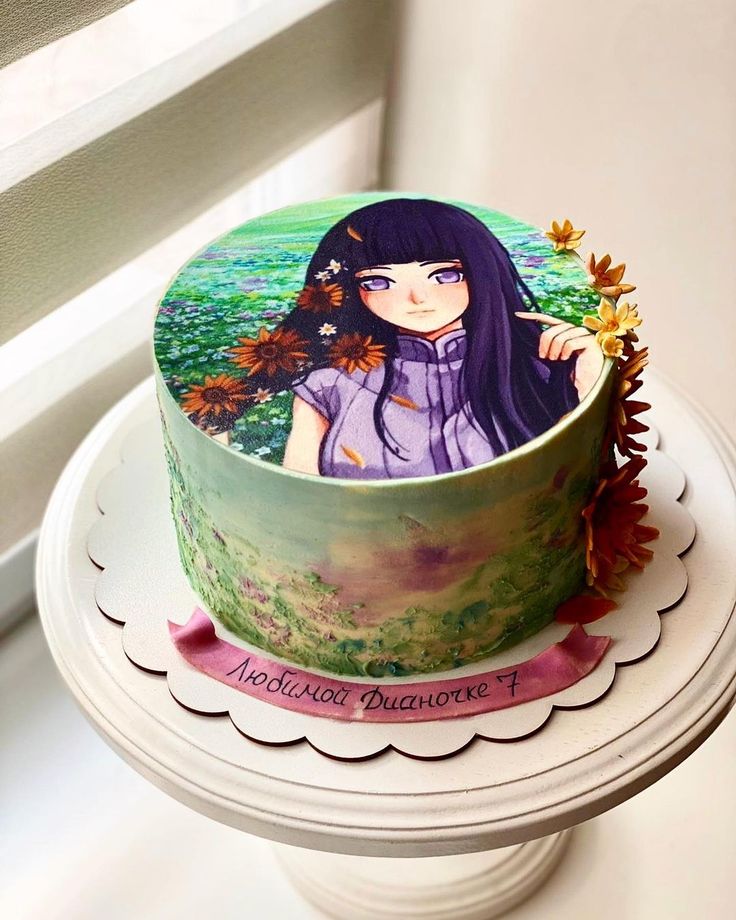 Birthday cake with anime girl illustration on green frosted surface with chocolate accent pieces