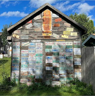 Wooden shed covered with many colorful license plates outdoors