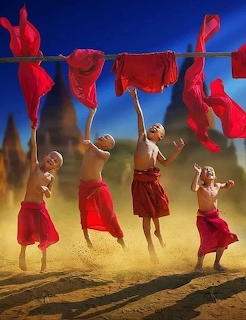 Cartoon illustration of happy little monks in orange robes smiling together