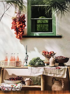 Rustic kitchen shelves with vegetables, bottles, plants and hanging garlic by window