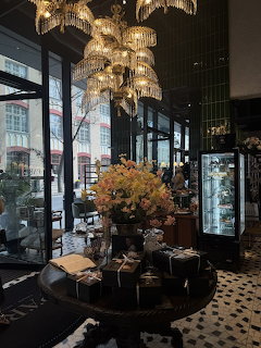 Parisian cafe and deli storefront with outdoor seating under an awning