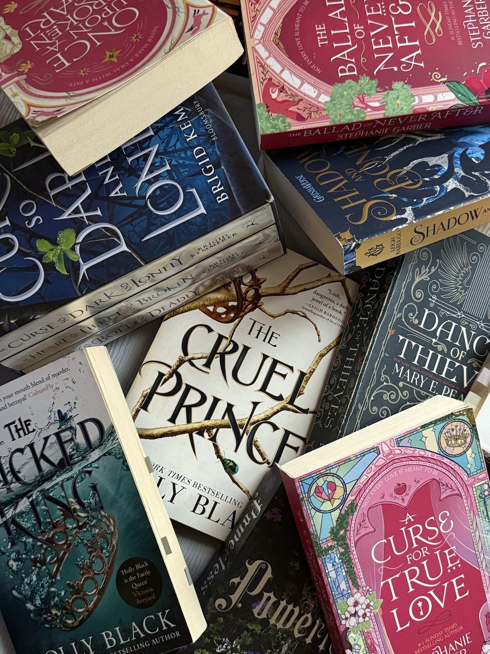 Overhead view of overlapping fantasy book covers including The Cruel Prince and The Wicked King