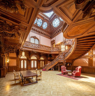 Ornate palace hall with carved wood paneling, grand staircase, domed skylight, and antique furniture