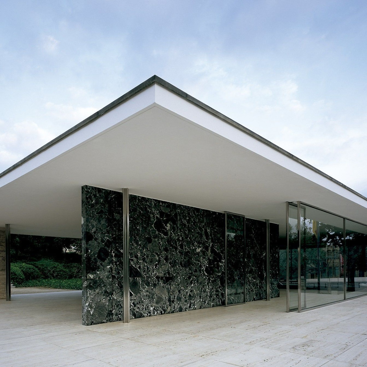 Modernist glass pavilion with white roof and dark marble walls