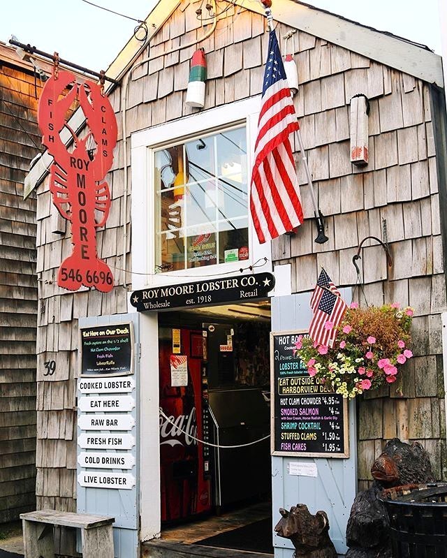 New England seafood restaurant entrance with red lobster sign and American flags on shingled building