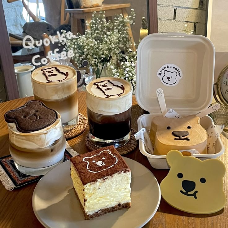 Character-themed coffee drinks and cake desserts with cute face designs on a wooden table