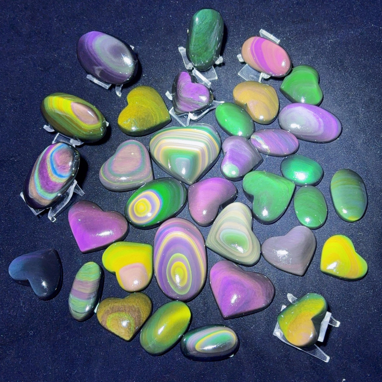 Colorful polished stones with pastel swirls scattered on a dark background