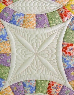 Cream quilted center with feather stitching framed by pastel floral patchwork squares