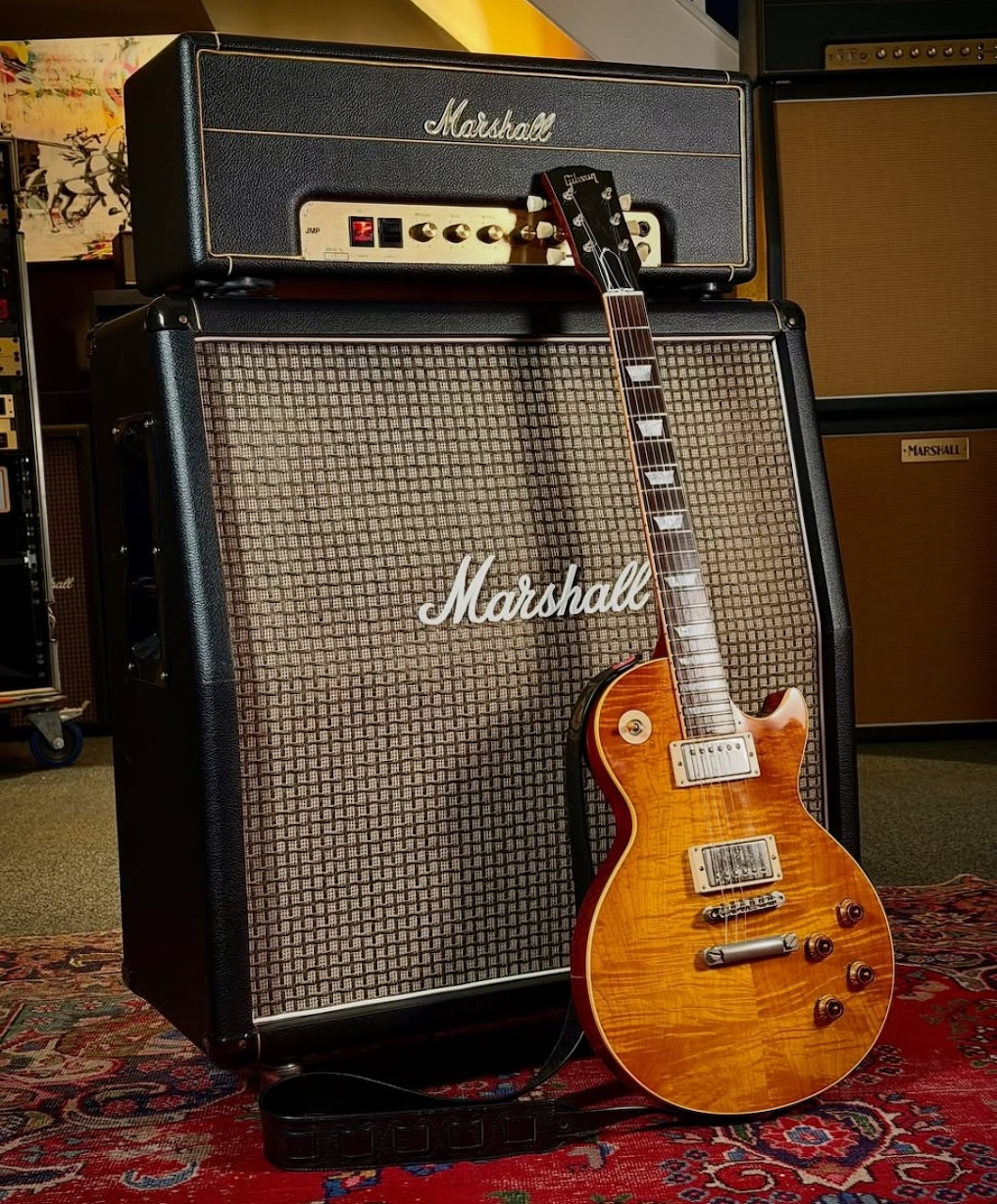 Sunburst Les Paul electric guitar leaning against a Marshall amplifier cabinet and head