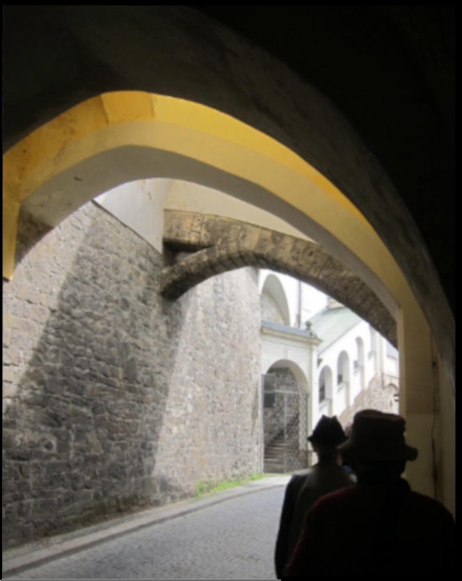 Narrow cobblestone alley in Passau, Germany with pastel historic buildings