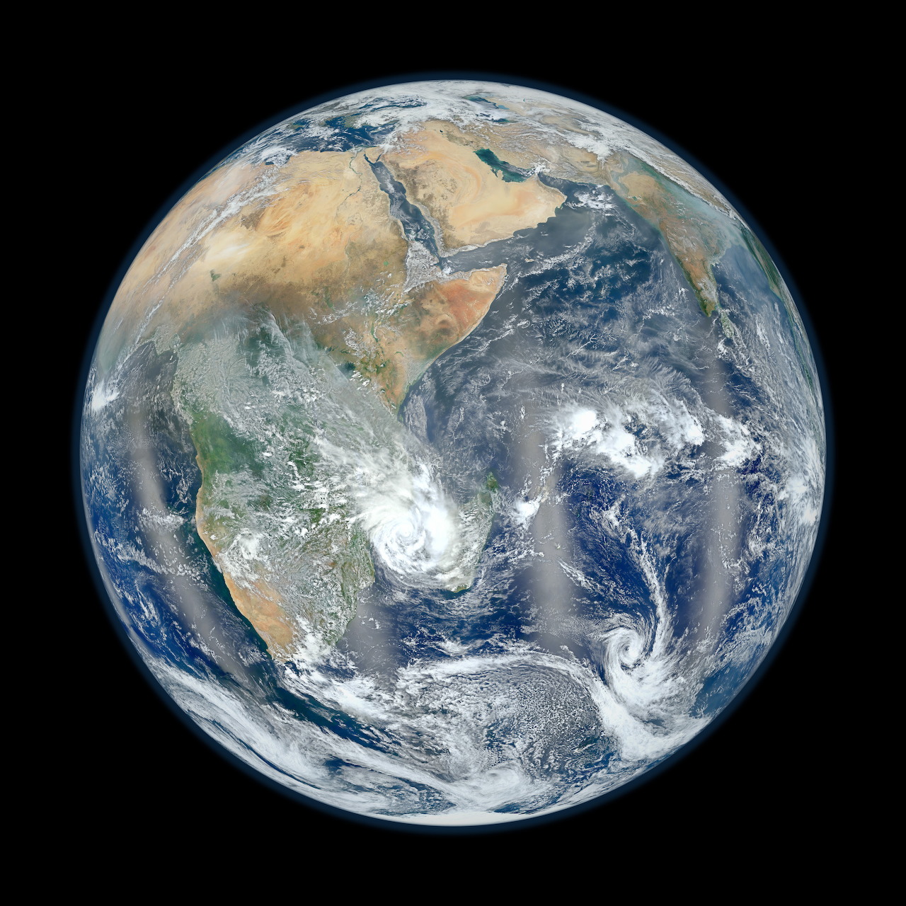 Full view of planet Earth from space showing continents, blue oceans, and white cloud swirls on black background