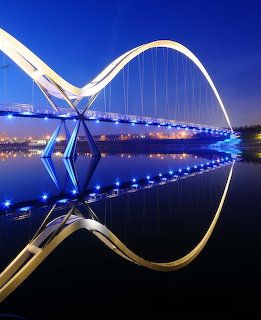 Infinity Bridge at night in Stockton reflected in calm water
