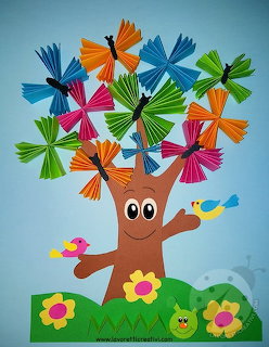 Smiling cartoon tree with colorful paper butterflies and birds, children's craft activity