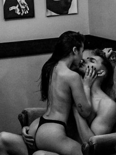 Black and white photo of two women intimately embracing indoors