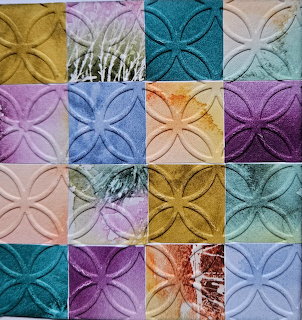 Colorful patchwork quilt with embossed floral patterns in multiple fabric squares
