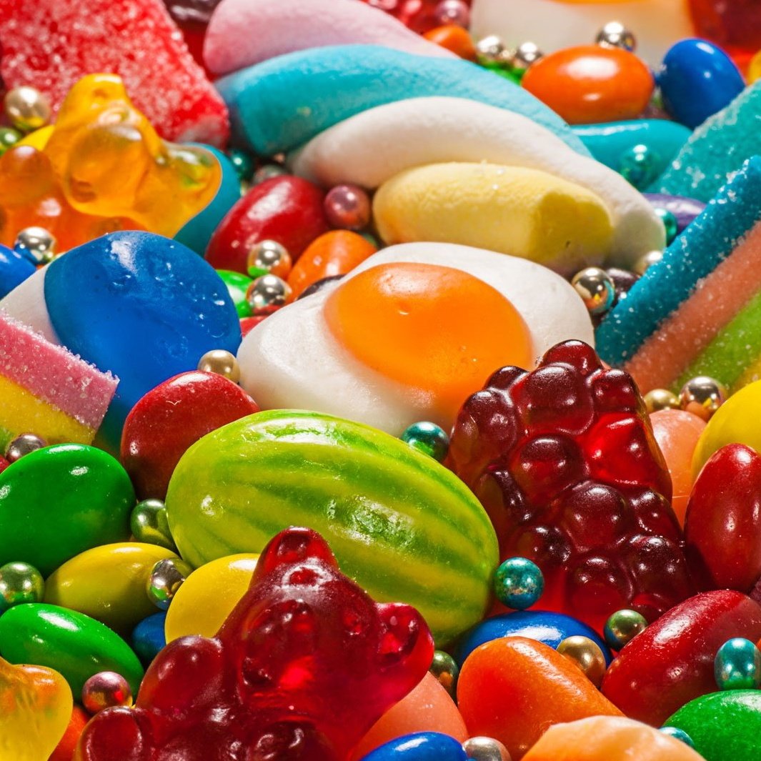 Close-up of mixed colorful candies, gummies, jelly sweets, and candy-coated chocolates