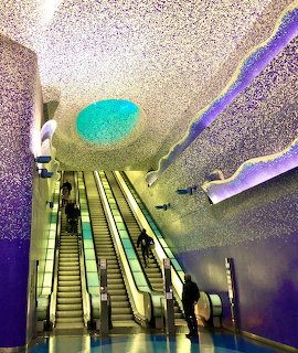 Colorful interior of Toledo Metro Station in Naples with mosaic ceiling and escalators