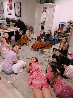 Group of girls in pajamas gathered on a bedroom floor during a sleepover