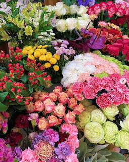 Abundant colorful flower bouquets including roses and carnations in various colors at a flower market