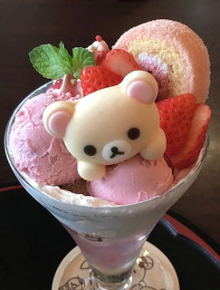 White cartoon bear character in glass parfait with strawberries, pink ice cream, and wafer cookies