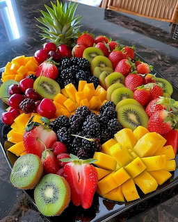 Circular platter with assorted fresh cut fruits arranged in colorful sections