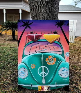 Colorful painting of a turquoise VW Beetle with surfboards and palm trees, leaning against a tree outside