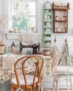 Vintage sewing room with antique machine, wooden table, mint shelves, lace fabrics, and window light