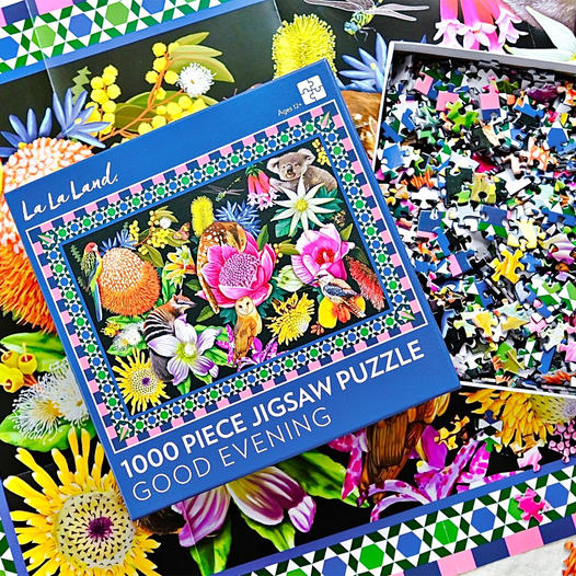 Colorful jigsaw puzzle box with loose pieces and bright floral artwork